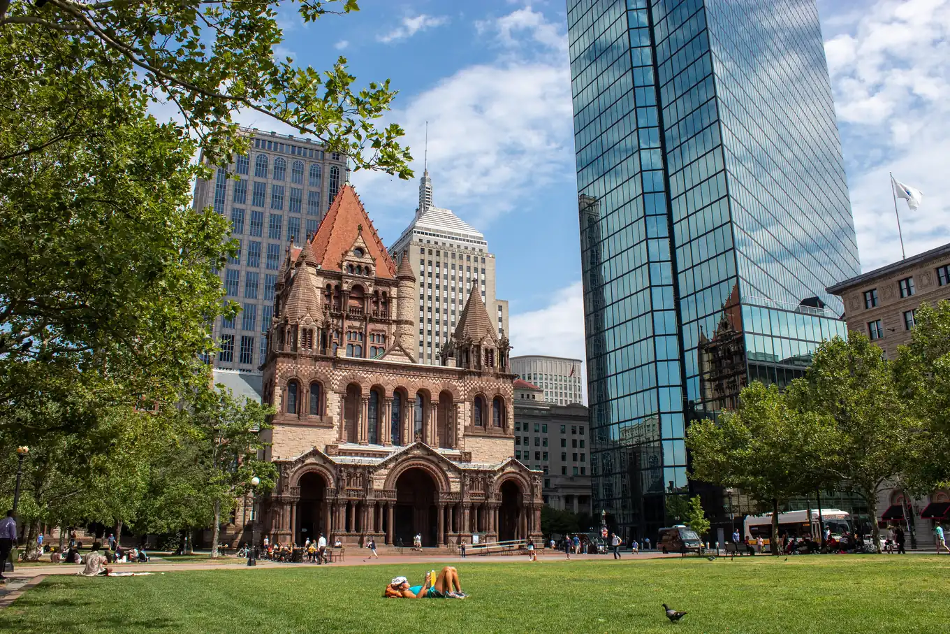 Trinity Church in Copley Square, Boston, its stone tower beside a reflective glass skyscraper.
