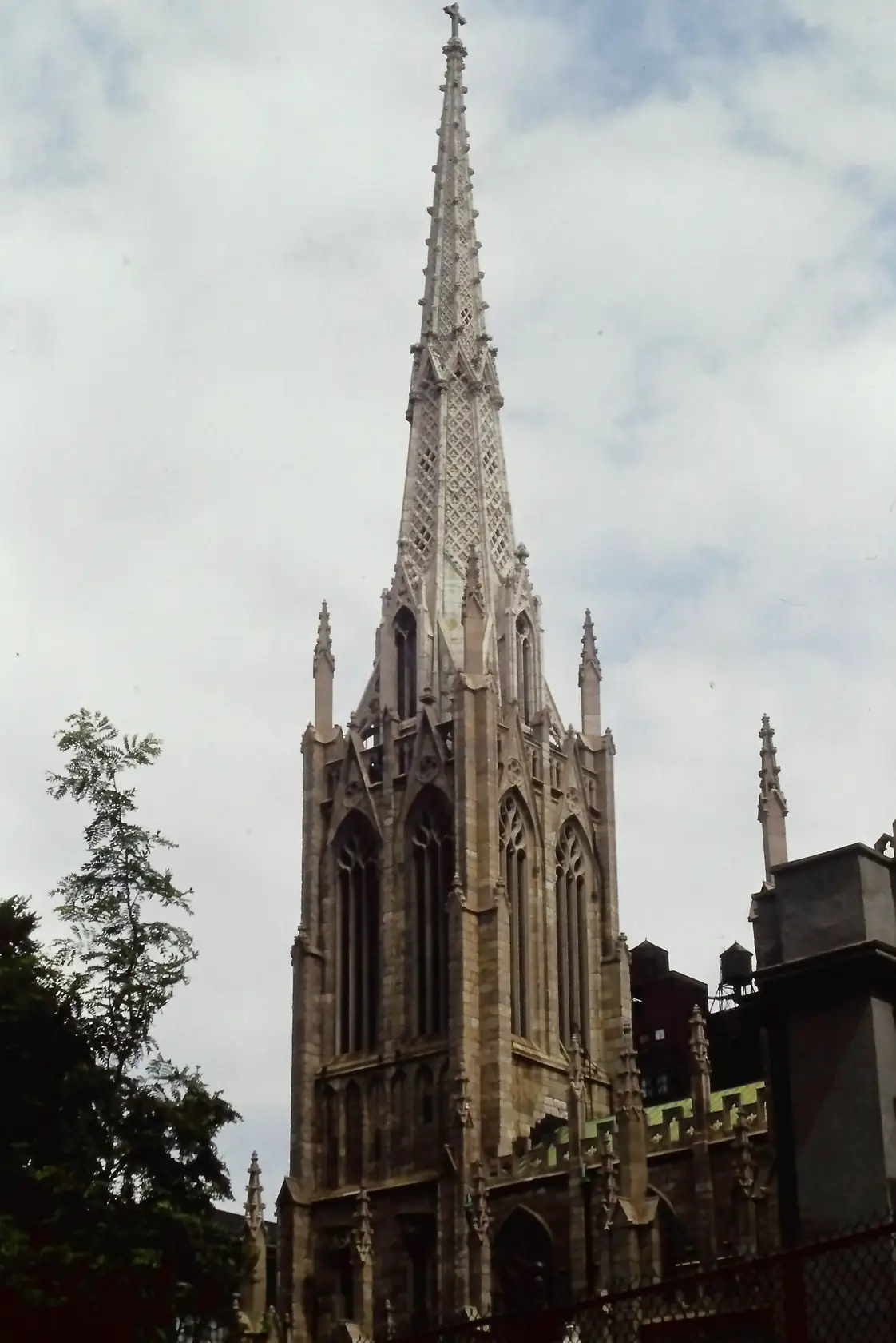 Grace Church on Broadway in New York, a Gothic Revival stone church with a tall steeple, seen from the sidewalk.